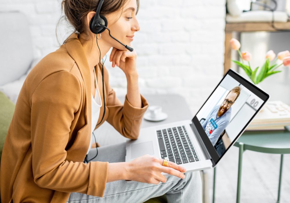 Frau arbeitet mit Headset aus dem Homeoffice Frau arbeitet mit Headset aus dem Homeoffice
