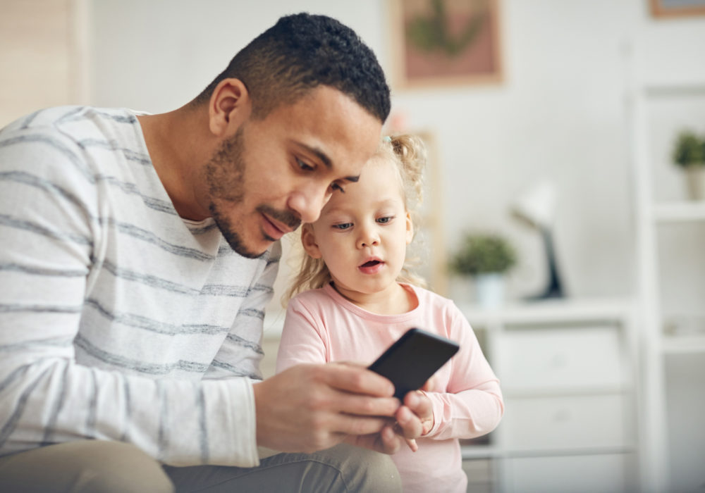 Mann arbeitet mit Smartphone im Homeoffice