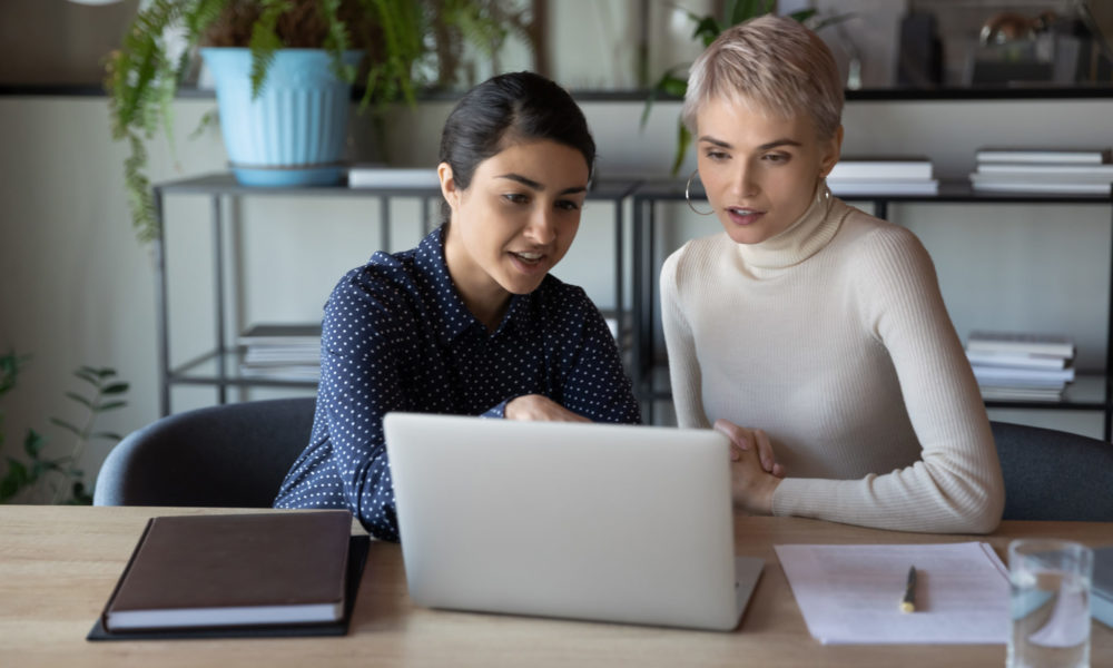 Zwei Kolleginnen schauen sich HR Software am Desktop an