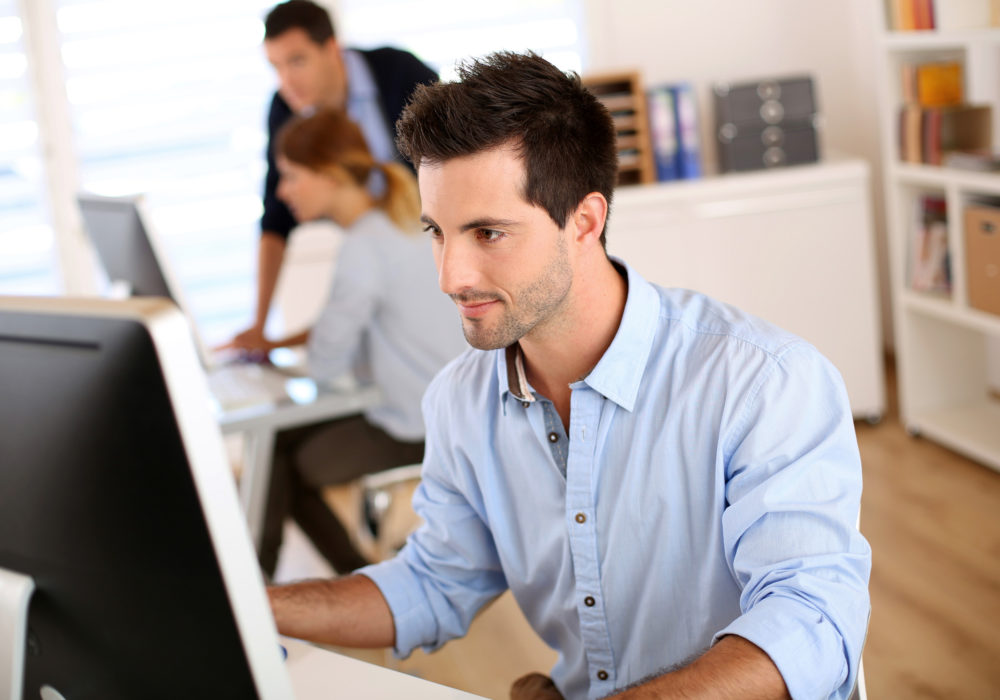 Mann arbeitet am Desktop im Büro
